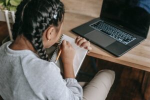 crop smart girl studying with notepad and laptop